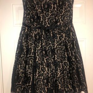 A tan fabric  dress with black lacing all over